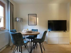 因斯布鲁克Gemütliche Wohnung mit Gartenblick的一间带桌椅和电视的用餐室