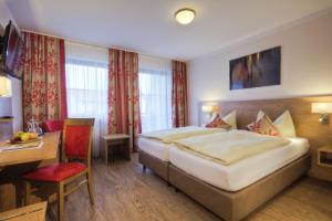 巴特恩多夫斯托宾格特蒙酒店的酒店客房设有一张大床和一张书桌。