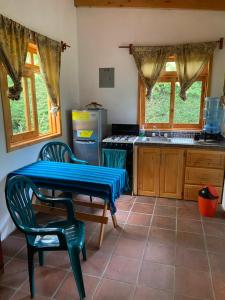 圣克鲁斯拉拉古纳Lake Front Cabin的厨房配有桌子、两把椅子和炉灶。