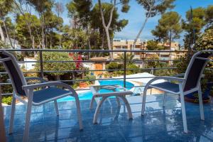 罗达德瓦拉HOTEL La Estrella del Mediterráneo的一个带两把椅子的阳台和一个游泳池