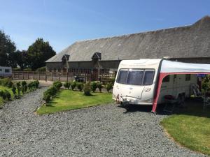 雷德斯Camping at Le Clos Castel的停在房子前面的白色大篷车