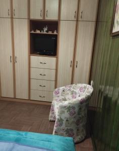 卡尔派尼西翁Casa D' Irene的一间卧室配有椅子、电视和橱柜
