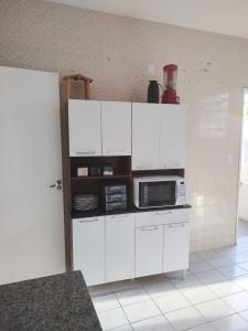 萨尔瓦多Maré Hostel Itapuã的厨房配有白色橱柜和微波炉