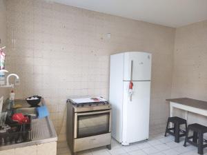 萨尔瓦多Maré Hostel Itapuã的厨房配有白色冰箱和炉灶。