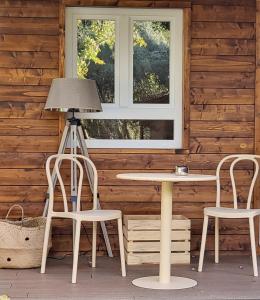 VenturadaCasa Rural de Rafael Cabañas de Madera的小屋内的一张桌子和两把椅子及一盏灯