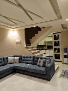 Ash ShāghūrVilla Jana chalet - Private Villa - Dead Sea - Jordan的带沙发和楼梯的客厅