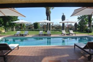 圣莱昂Villa Carlotta Resort的一个带椅子和遮阳伞的游泳池