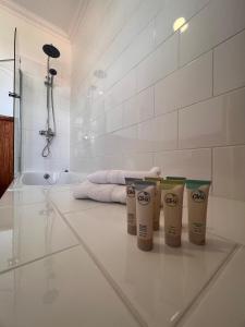 Villa Tehuelche Estancia Río Penitente的浴室铺有白色瓷砖地板,配有三杯