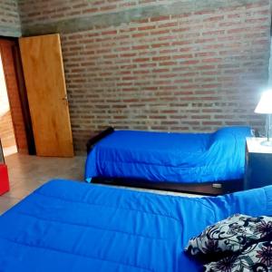 圣罗莎Cabaña Sarita的一间设有两张床和砖墙的房间