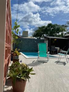 邦比尼亚斯Pousada Casa Mariscal的一个带两把椅子的庭院和一个游泳池