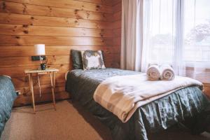 罗托鲁瓦Comfortable Cosy Retreat的一间卧室配有带毛巾的床和窗户。