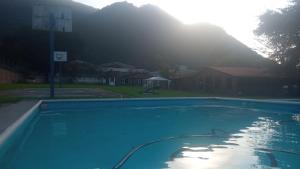 奥里萨巴Multialojamientos Pico de Orizaba的一个空的游泳池,背景是一座山