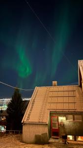 特罗姆瑟Cozy little house in Tromsø city的天空中光辉灿烂的房子