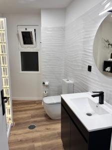 丰沙尔Luxury View Apartment Funchal的一间带水槽、卫生间和镜子的浴室