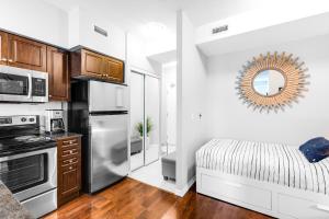 多伦多AOC Suites - High-Rise Condo - City View的厨房配有不锈钢冰箱和1张床