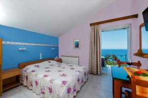 Khelmáta凯法利尼亚艾洛斯一室公寓酒店的一间卧室配有一张床,享有海景