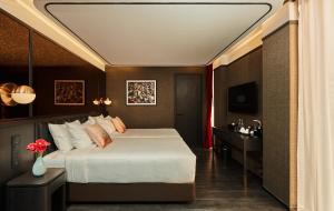曼谷The Ember Hotel Khaosan的一间卧室配有一张床、一张桌子和一台电视
