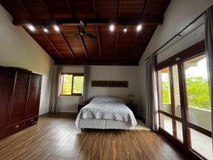 因比图巴Casa de praia no Rosa - vista para Lagoa de Ibiraquera的一间卧室设有一张床和木制天花板