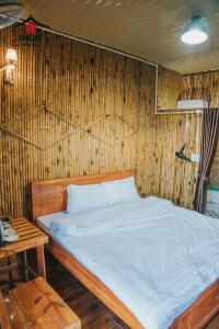 木州县SAKURA House - Vườn Đào的木墙客房的一张床位