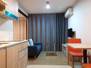 普吉镇4 Floor - Centrio Condominium near Shopping Malls and Andamanda Water Park的一间带蓝色沙发的客厅和一间厨房