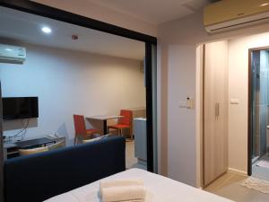 普吉镇4 Floor - Centrio Condominium near Shopping Malls and Andamanda Water Park的客房设有桌椅和窗户。