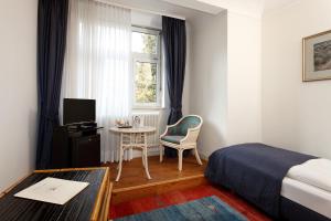 海德堡阿特兰蒂克帕克酒店的酒店客房设有床、桌子和窗户。