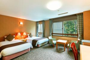 那须盐原市KAMENOI HOTEL Shiobara的酒店客房设有两张床和窗户。