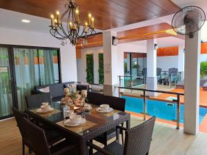 奈扬海滩The Chic Pool Villa的一间带桌椅的用餐室和一个游泳池