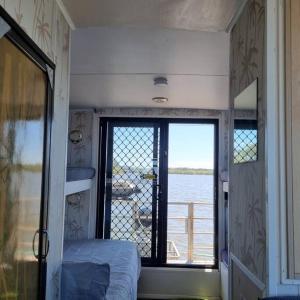玛志洛The one & only Houseboat Hire on Maroochy River的一间卧室设有水景窗户