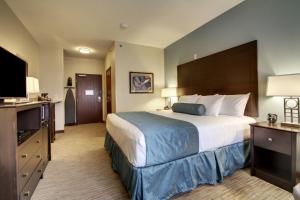 道奇堡Cobblestone Inn & Suites - Fort Dodge的一间酒店客房,配有一张大床和一台平面电视