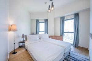 迪拜Expo Village Serviced Apartments的卧室设有一张白色大床和一扇窗户。