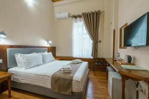 布哈拉马力卡布哈拉酒店的一间卧室配有一张床、一张书桌和一台电视