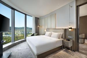 济南济南君瑞酒店的卧室设有一张白色大床和大窗户