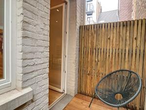 鲁汶Nieuw appartement in Leuven centrum!的木栅栏旁门廊上的椅子