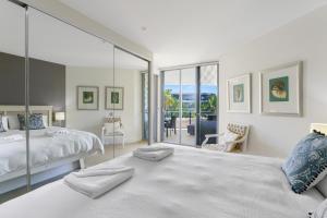 金斯克里福Cotton Beach Resort - Tweed Coast Holidays ®的一间卧室设有一张床和玻璃墙