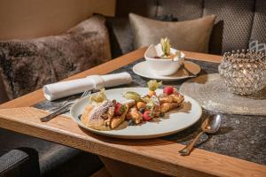 蓬高圣约翰唐纳霍夫阿尔卑斯生活方式酒店的桌子上放着一盘食物的桌子