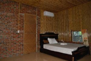 宁平Ninh Binh Bungalow Homestay的卧室配有砖墙内的床铺