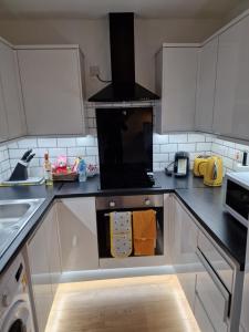 诺丁汉Balco Sherwood House - 2 Bedrooms, 5 beds - Sky tv and internet的厨房配有白色橱柜和炉灶烤箱。