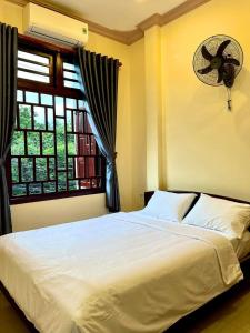 Ấp Bình HưngT's House Motel的卧室配有白色的床和窗户。