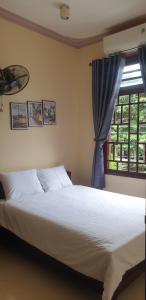 Ấp Bình HưngT's House Motel的一间卧室设有一张大床和一个窗户。