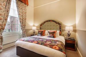 奥斯威斯The Wynnstay Hotel, Oswestry, Shropshire的一间卧室设有一张大床和一个窗户。