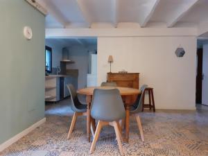 蒙彼利埃Montpellier Boutonnet avec jardin的一间带木桌和椅子的用餐室