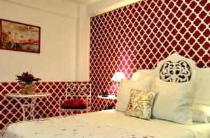 科尔多瓦Vintage apartment的一间卧室配有一张红色墙壁的床