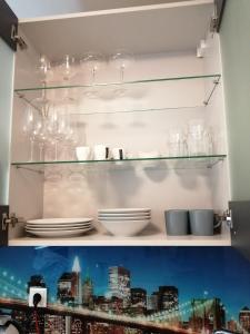 维也纳Apartment Tesla的架子上装有盘子和玻璃杯