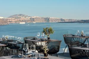 伊亚La Perla Villas and Suites - Adults Only的一间设有桌椅的海景餐厅