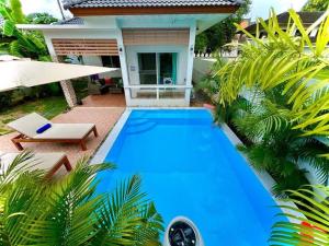 苏梅岛Holiday house near Lamai with swimming pool. 2 bedrooms的房子前面的蓝色游泳池