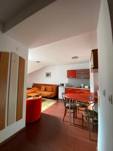 波罗维茨巴尔别墅酒店的厨房以及带红色桌椅的起居室。