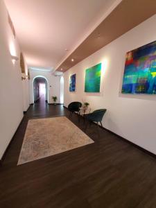 那不勒斯Palazzo Cappuccini Art Relais的走廊上设有两把椅子和墙上的绘画作品