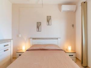 普利兹巴Apartments Žaknić的一间卧室配有床,两台桌子上有两个灯