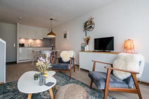 霍勒姆Appartement, Kaap 123 - Ameland的一间带桌椅的客厅和一间厨房